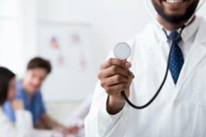 Doctor with stethoscope, medical staff working on background