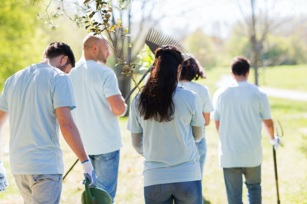 happy volunteers with seedlings and garden tools