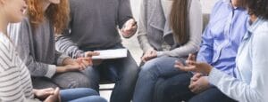 Psychologist talking with people at support group meeting