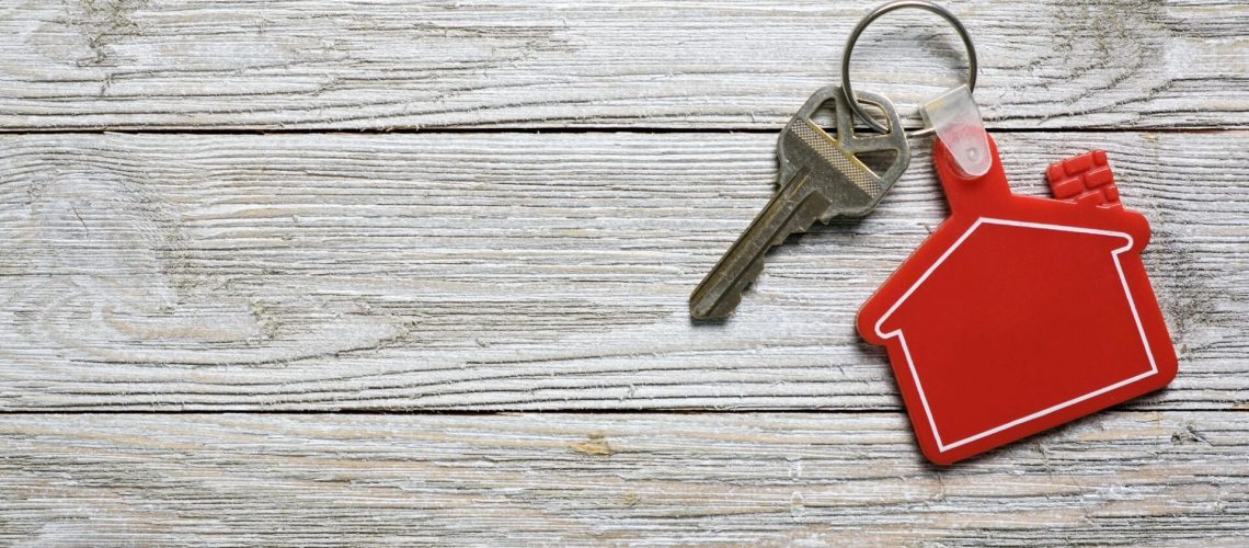 House key with red house shape keychain for real estate concept